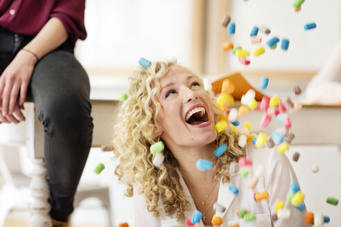 Blonde Geschäftsfrau lacht über fallende Marshmellows - PESF00563