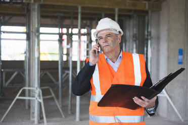 Man on the phone wearing safety vest in building under construction - DIGF02523