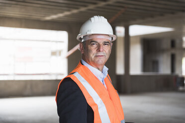 Porträt eines Mannes mit Sicherheitsweste in einem im Bau befindlichen Gebäude - DIGF02543