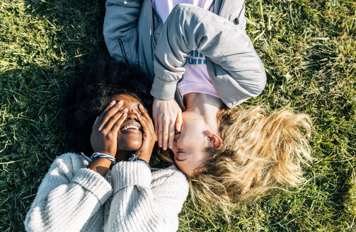 Two best friends telling secrets lying in the grass - MGOF03339