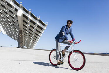 Young businessman on fixie bike outdoors - GIOF02572
