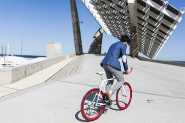 Young businessman on fixie bike outdoors - GIOF02573