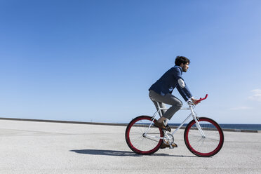 Junger Geschäftsmann auf Fixie-Fahrrad im Freien - GIOF02574