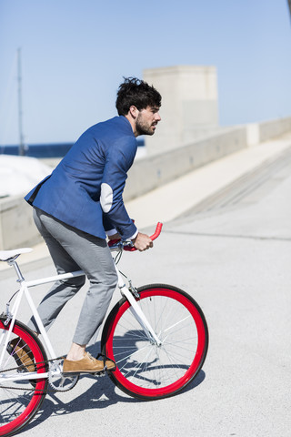 Junger Geschäftsmann auf Fixie-Fahrrad im Freien, lizenzfreies Stockfoto