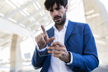 Young businessman using futuristic portable device - GIOF02596