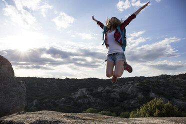 Spanien, Madrid, junge Frau springt während eines Trekkingtages - ABZF02008