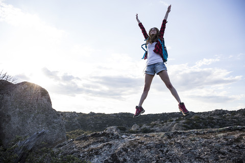 Spanien, Madrid, junge Frau springt während eines Trekkingtages, lizenzfreies Stockfoto