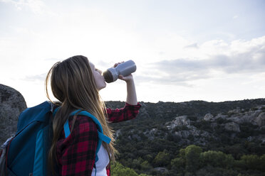 Spanien, Madrid, junge Frau trinkt während eines Trekkingtages - ABZF02010