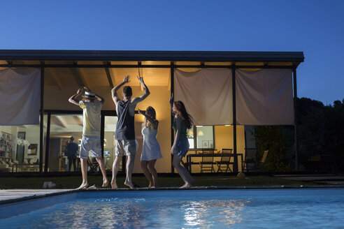 Vier glückliche Freunde tanzen am Pool - ZOCF00300