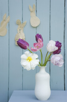Blumen in einer Vase und selbstgemachte Osterdekoration an der Wand - GISF00285