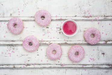 Sechs Krapfen mit rosa Zuckerguss und Zuckergranulat auf Holz - LVF06107