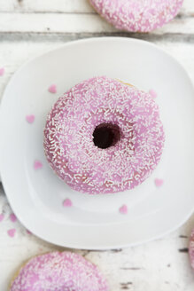 Krapfen mit rosa Zuckerguss und Zuckergranulat auf dem Teller - LVF06110