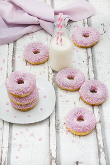 Krapfen mit rosa Zuckerguss und Kristallzucker und eine Flasche Milch - LVF06111