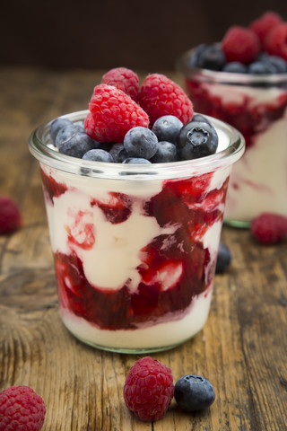 Glasses of Greek yogurt with berry groats, fresh blueberries and raspberries stock photo