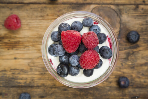 Glass of Greek yogurt with breey gorats, fresh blueberries and raspberries, close-up - LVF06117