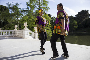 Father and adult daughter wearing traditional Brazilian clothing dancing together - ABZF02013