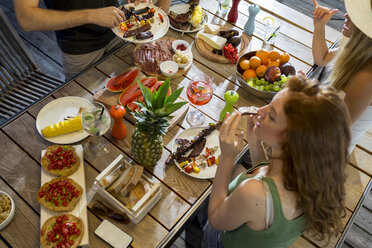 Freunde beim Abendessen am Tisch im Freien - ZOCF00326