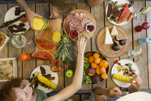 Freunde beim Abendessen am Tisch im Freien - ZOCF00329