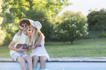 Young couple relaxing at pool edge - ZOCF00343