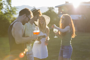 Four friends having fun in the garden at sunset - ZOCF00346