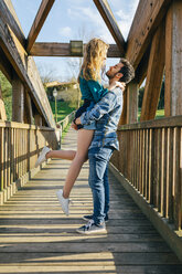 Young couple in love on wood bridge - DAPF00749