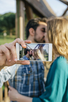 Küssendes junges Paar macht Selfie mit Smartphone - DAPF00765