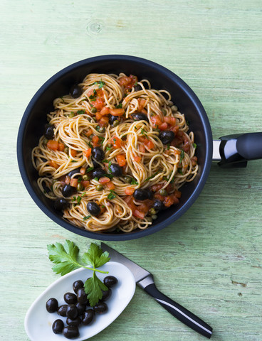 Spaghetti mit Tomaten, Oliven und Kapern in der Pfanne, lizenzfreies Stockfoto