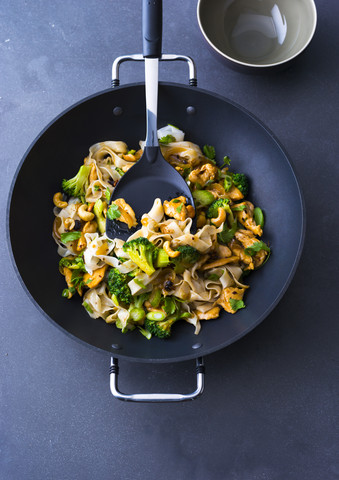 Gebratene Nudeln mit Huhn, Brokkoli und Cashewnüssen im Wok, lizenzfreies Stockfoto