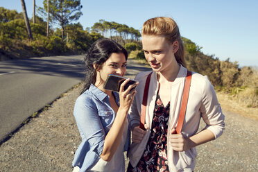 South Africa, Cape Town, Signal Hill, two young women with cell phone on a trip - SRYF00527