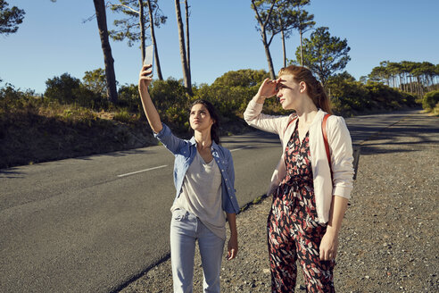 South Africa, Cape Town, Signal Hill, two young women with cell phone on a trip - SRYF00529