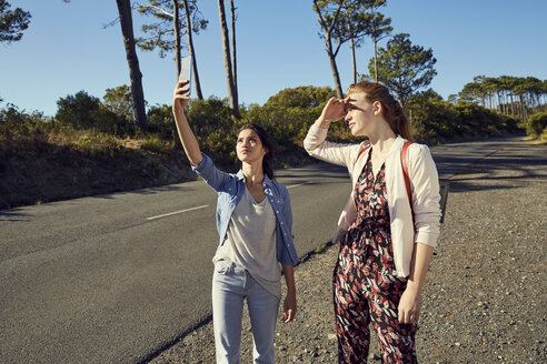 Südafrika, Kapstadt, Signal Hill, zwei junge Frauen mit Mobiltelefon auf einem Ausflug - SRYF00529