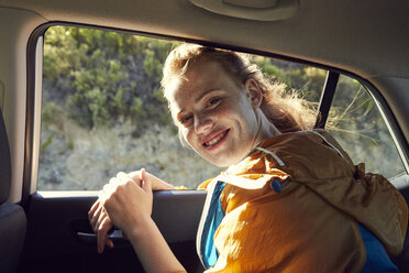 Smiling young woman on the back seat of a car - SRYF00543