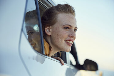 Smiling young woman looking out of a car - SRYF00546