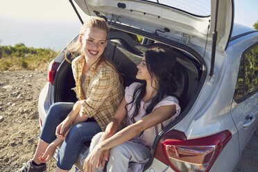 South Africa, Cape Town, Signal Hill, two young women sitting in the boot of a car - SRYF00554