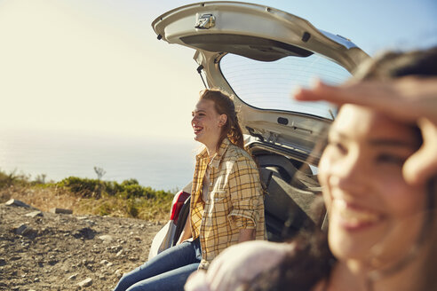 Südafrika, Kapstadt, Signal Hill, zwei glückliche junge Frauen an einem Auto an der Küste - SRYF00555