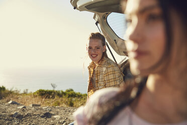 Südafrika, Kapstadt, Signal Hill, zwei junge Frauen an einem Auto an der Küste - SRYF00556