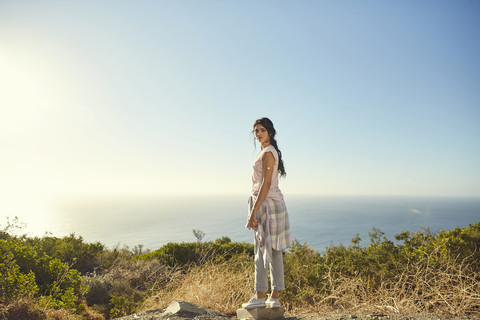 Südafrika, Kapstadt, Signal Hill, junge Frau steht an der Küste, lizenzfreies Stockfoto