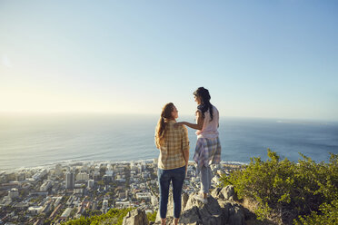 South Africa, Cape Town, Signal Hill, two young women overlooking the city and the sea - SRYF00560