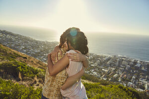 Südafrika, Kapstadt, Signal Hill, zwei junge Frauen umarmen sich über der Stadt - SRYF00567