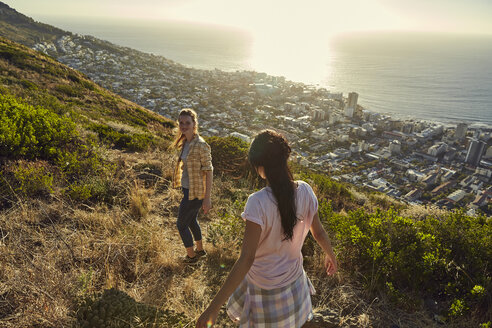 South Africa, Cape Town, Signal Hill, two young women hiking above the city - SRYF00570