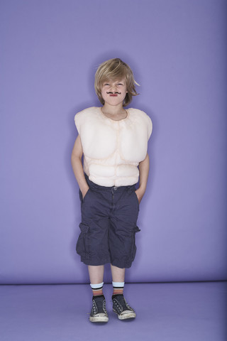 Porträt eines kleinen Jungen, der als Muskelmann verkleidet ist, lizenzfreies Stockfoto