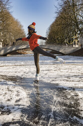 Woman ice skating on canal - MFF03508