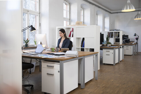 Frau arbeitet am Schreibtisch im Büro - FKF02246