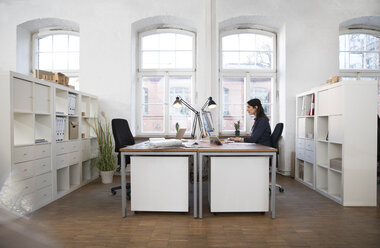 Frau arbeitet am Schreibtisch im Büro - FKF02248