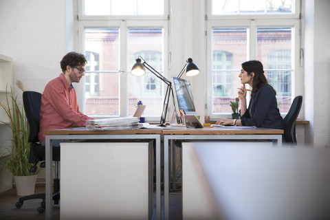 Mann und Frau arbeiten im Büro, lizenzfreies Stockfoto