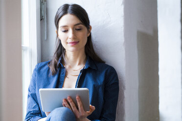 Woman using tablet at the window - FKF02260