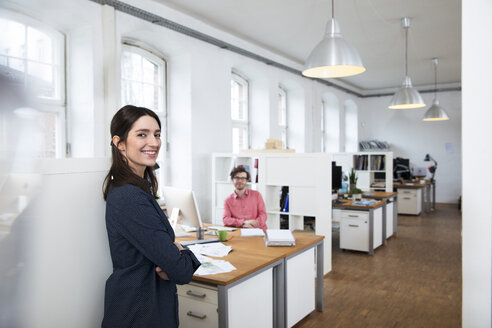 Portrait of smiling woman and man in office - FKF02271