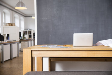 Laptop on desk in empty office - FKF02278