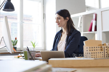 Woman working at desk in office - FKF02298