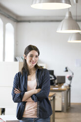 Portrait of confident woman standing in office - FKF02309